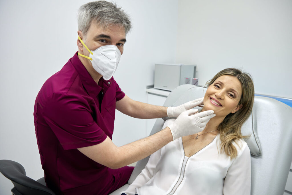 El Dr. Pérez-Herrezuelo explora el rostro de una paciente en su consulta de Valencia